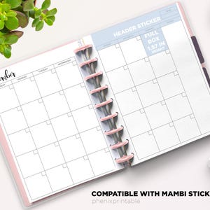 May include: A disc-bound planner open to a December monthly calendar layout with white pages, black grid lines, and pink binding discs. The page includes text labels for days of the week, a header sticker section, and a full box measuring 1.57 inches in height.