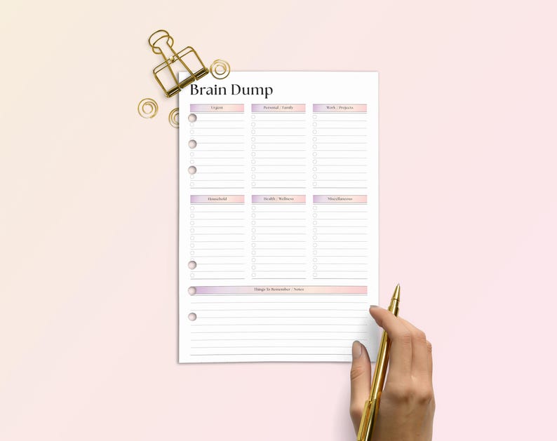 Op de afbeelding: Een plannerpagina met de titel "Brain Dump" en secties voor lijsten. De pagina is wit met een roze en paarse gradi&euml;nt aan de boven- en onderkant. Een gouden pen en paperclip liggen naast de pagina op een roze achtergrond.