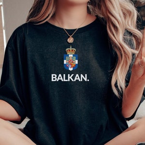 May include: A black t-shirt with a white print of a coat of arms and the word "BALKAN."