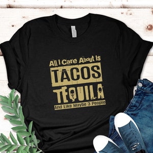 Pode incluir: Camiseta preta com um gr&aacute;fico dourado que diz "All I care about is tacos tequila and like maybe 3 people".
