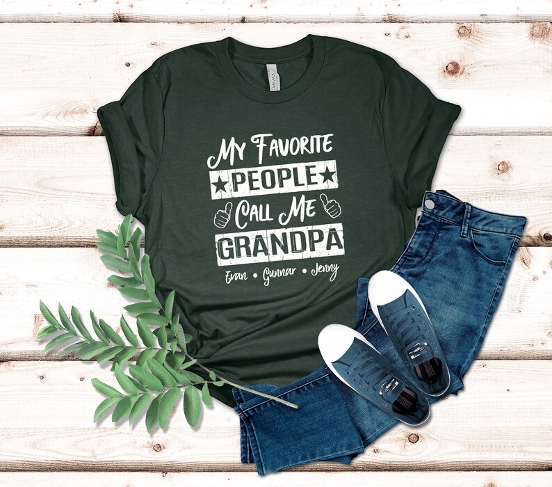 May include: A dark green t-shirt with a white graphic that says "My Favorite People Call Me Grandpa" with the names Evan, Gunnar, and Jenny underneath.