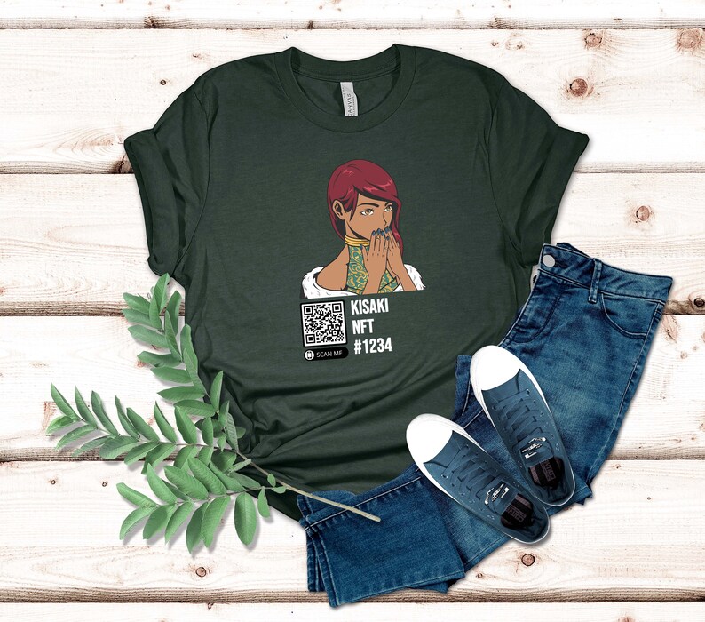 May include: Dark green t-shirt featuring an illustration of a woman with red hair and a QR code. The text on the shirt reads "KISAKI NFT #1234" with a "SCAN ME" prompt. The shirt is paired with blue jeans and white-soled sneakers.