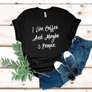 May include: Black t-shirt with white text that reads "I like coffee and maybe 3 people."