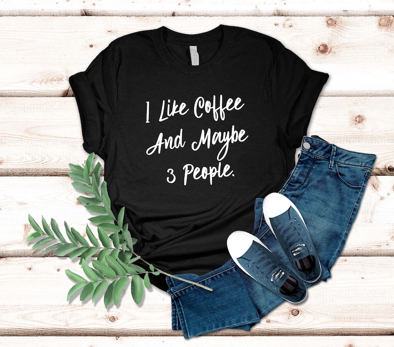 May include: Black t-shirt with white text that reads "I like coffee and maybe 3 people."