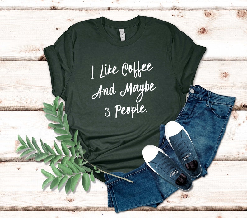 May include: A dark green t-shirt with the text "I like coffee and maybe 3 people." printed in white.