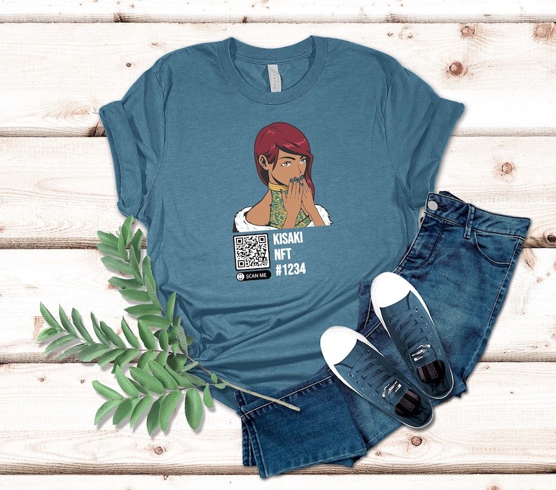 May include: Teal t-shirt featuring a graphic of a woman with red hair, covering her mouth. The shirt includes a QR code and the text "KISAKI NFT #1234". The shirt is paired with blue jeans and white sneakers.