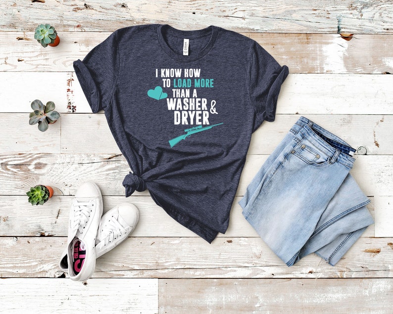 May include: A dark blue t-shirt with the text "I know how to load more than a washer & dryer" in white with a teal rifle and two teal hearts.