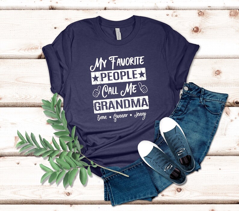 May include: Navy blue t-shirt with white text that reads "My Favorite People Call Me Grandma" with three names listed below: Evan, Gunnar, Jenny.