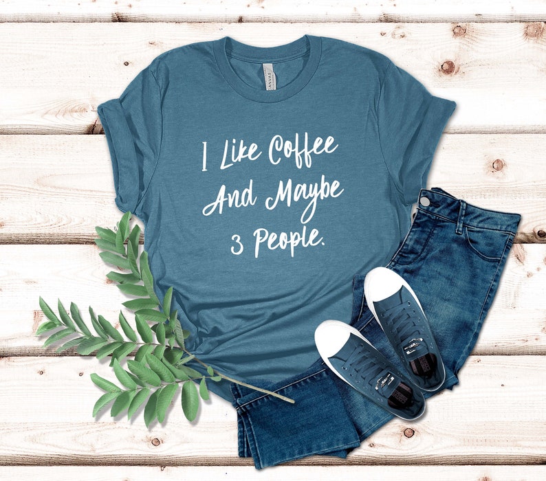 May include: A teal blue t-shirt with the text "I like coffee and maybe 3 people." printed in white.