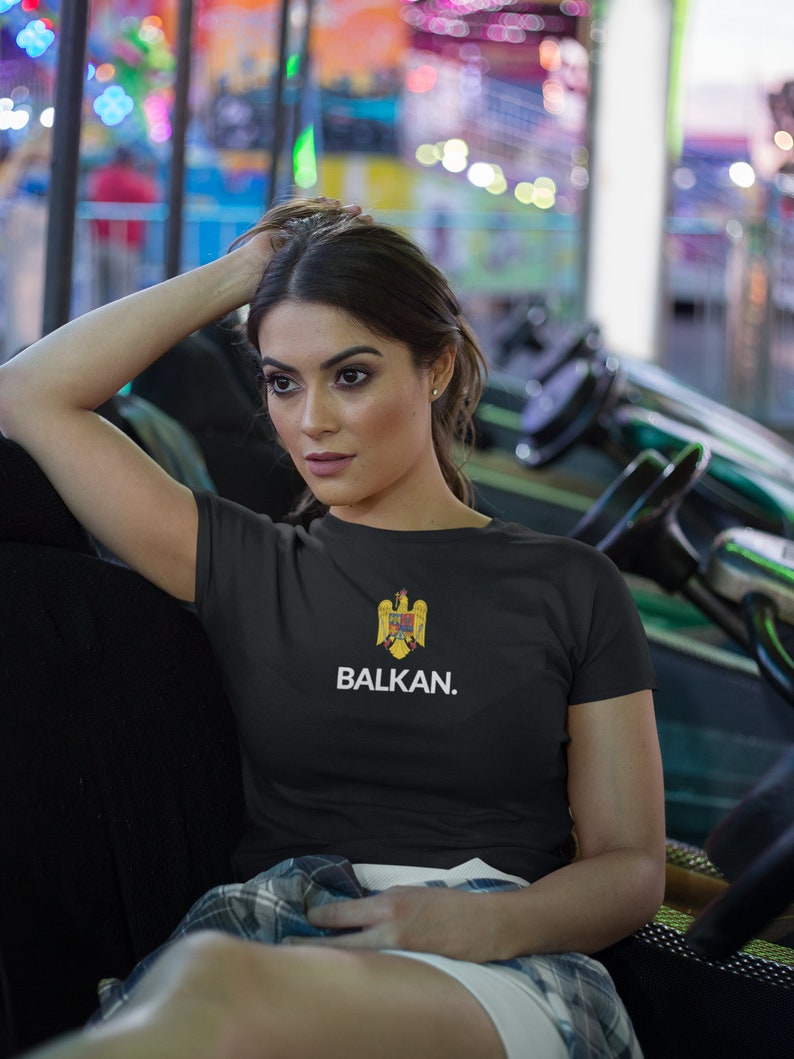 May include: A black t-shirt with a white print that says "BALKAN." The print also features a yellow and red eagle emblem.