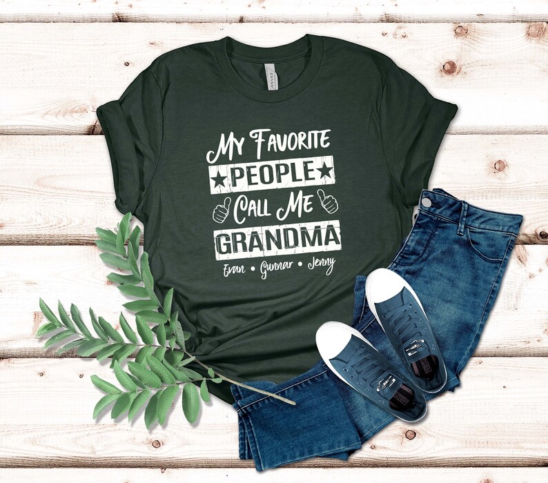 May include: A dark green t-shirt with the text "My Favorite People Call Me Grandma" in white with stars and thumbs up. The names Evan, Gunnar, and Jenny are listed below the text.