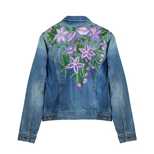 May include: A blue denim jacket with embroidered purple and green flowers on the back.