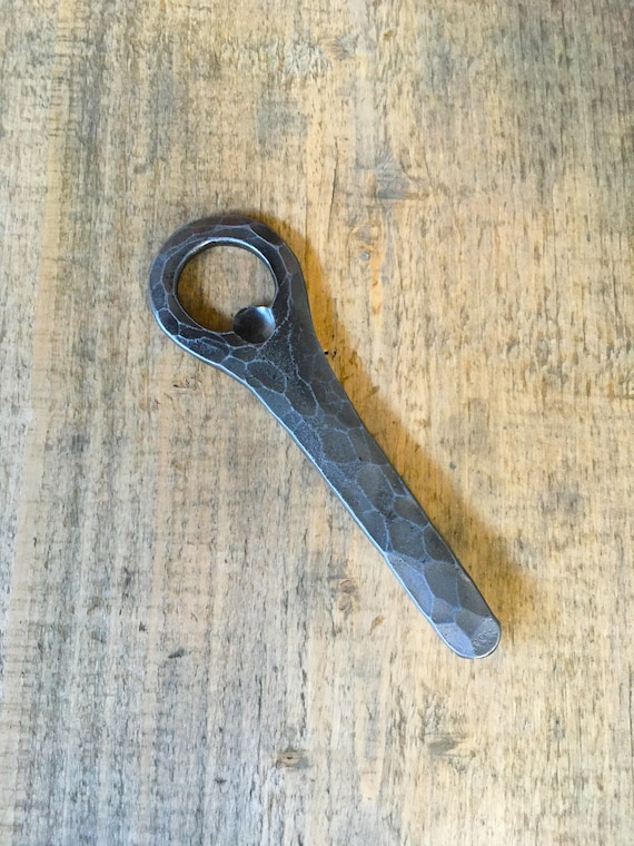 A blacksmith actually hammered this bottle opener from raw steel — you can see the hammer marks, and it will outlast everyone at the party.