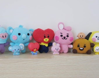 Könnte beinhalten: Eine Sammlung von gehäkelten Plüschtieren mit Charakteren der beliebten K-Pop-Gruppe BTS. Die Spielzeuge sind alle in verschiedenen Farben und haben unterschiedliche Gesichtsausdrücke.