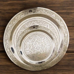 May include: Three silver-plated serving trays with intricate geometric designs. The trays are nested together, with the smallest tray in the centre featuring a starburst pattern.