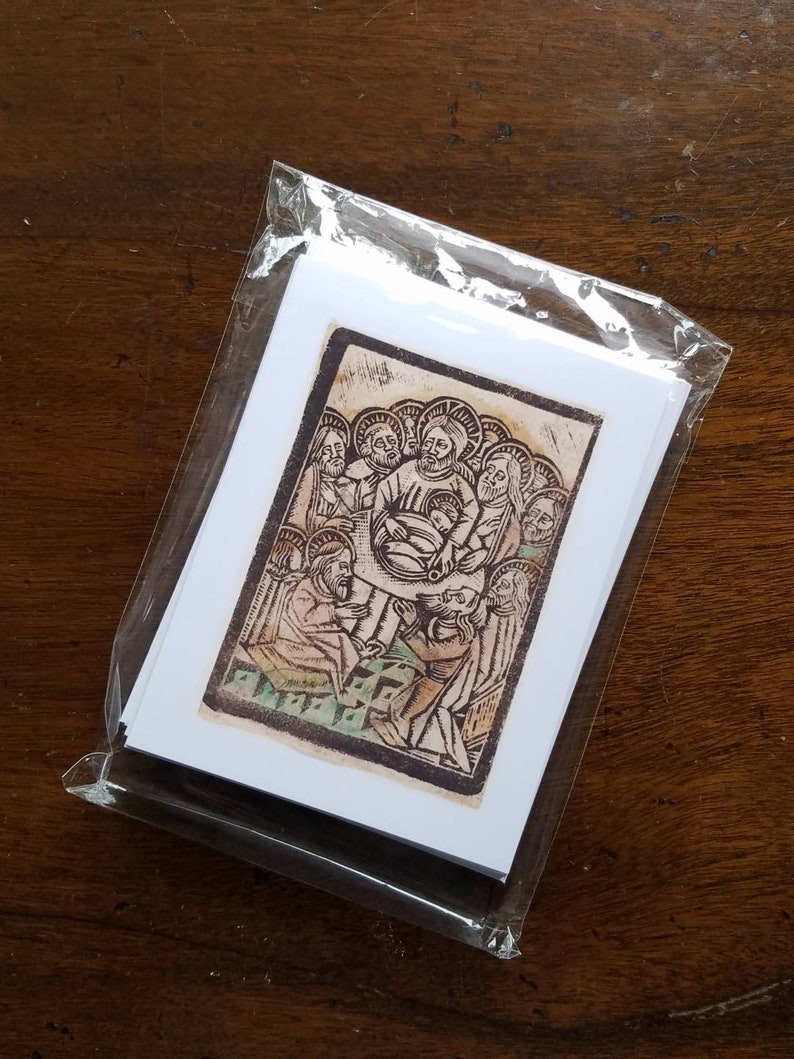 May include: A pack of art prints in a clear plastic sleeve. The prints showcase a religious illustration with figures in a warm colour palette. The artwork depicts a central figure surrounded by others, with detailed linework and a vintage aesthetic.