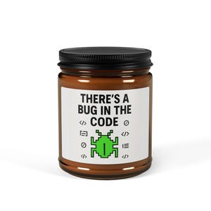 Può includere: Un barattolo di vetro marrone con coperchio nero. L'etichetta recita "THERE'S A BUG IN THE CODE" con una grafica a insetto verde pixelata e simboli di codifica. Un regalo umoristico per programmatori.