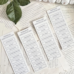 May include: A set of ten white bookmark cards with black text. Each card has a different category, such as "General Annotation Key", "Romance Annotation Key", "Thriller Annotation Key", and "Fantasy Annotation Key". Each card has a list of words related to the category, such as "characters", "quotes", "plot point", "foreshadowing", "important", "funny", "emotional", "love this", "hate this", "relationship goals", "happy", "romance", "funny", "sobbing", "relatable", "spice", "plot twist", "foreshadowing", "wtf is happening?", "don't do that!", "terrifying", "gross!", "characters", "quotes", "world building", "foreshadowing", "important", "action", "magic system", "spice".