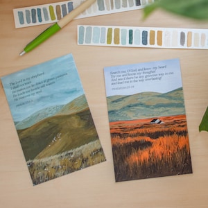 May include: Two watercolor paintings with inspirational quotes from the Bible. The first painting depicts a green and brown landscape with a flock of white birds. The quote reads "The Lord is my shepherd, I shall not want. He makes me lie down in green pastures; He leads me beside quiet waters. He restores my soul." Psalm 23:1-3. The second painting depicts a green and orange landscape with a small white house. The quote reads "Search me, O God, and know my heart; Try me and know my thoughts; And see if there be any grievous way in me, And lead me in the way everlasting." Psalm 139:23-24.