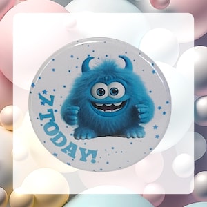 May include: A blue monster with a toothy grin and big eyes on a white round button with the text "7 TODAY!" in blue.