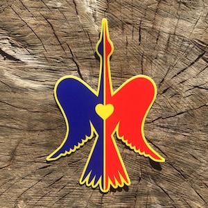 May include: A colorful sticker featuring a stylized bird design. The bird is split vertically, with one side blue and the other red. A yellow heart is in the center. The bird has yellow outlines and is set against a wood grain background.