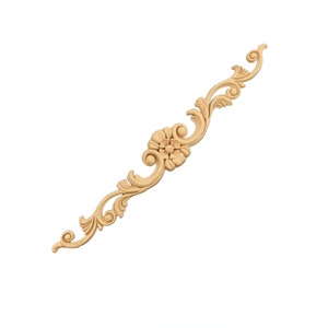 May include: A wooden decorative trim with a floral design. The trim is light brown and has a carved flower in the center.