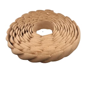 May include: A brown, coiled, decorative trim made of a textured material. The trim is shaped like a flower with multiple layers.