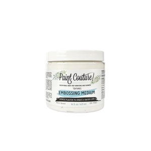 May include: A white jar of Paint Couture Embossing Medium, a water-based acrylic plaster to create a raised look. The jar is labeled with the brand name, product name, and size: 16 fl oz / 473 ml.