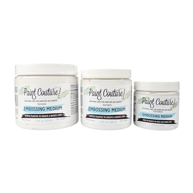 May include: Three white jars of Paint Couture Embossing Medium, a water-based acrylic plaster to create a raised look. The jars are labeled with the product name, size, and instructions. The jars are arranged in order of size, with the largest jar on the left and the smallest jar on the right.