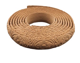May include: A roll of brown decorative trim with a repeating embossed pattern. The trim is made of a flexible material and can be used to add a decorative touch to furniture, walls, or crafts.
