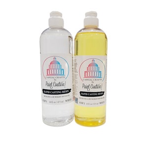 May include: Two clear plastic bottles of resin for crafting. The bottles are labeled "Capital Crafts by Paint Couture!" and "Rapid Casting Resin". The bottle on the left is labeled "Step 1" and the bottle on the right is labeled "Step 2". Both bottles are 16 fluid ounces.
