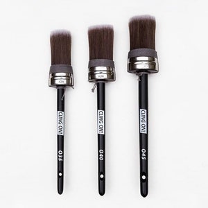May include: Three black-handled paint brushes with silver ferrules and white bristles. The brushes are labeled "CLING ON!" and have size numbers 035, 040, and 045.