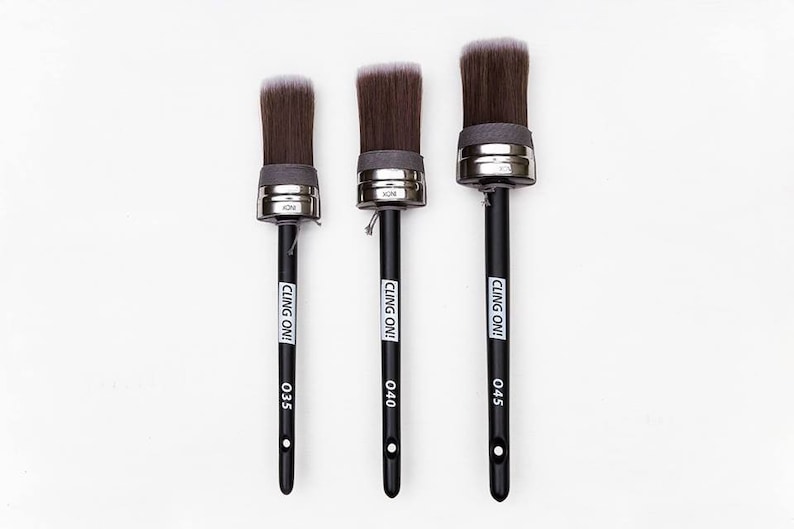 May include: Three black-handled paint brushes with silver ferrules and white bristles. The brushes are labeled "CLING ON!" and have size numbers 035, 040, and 045.