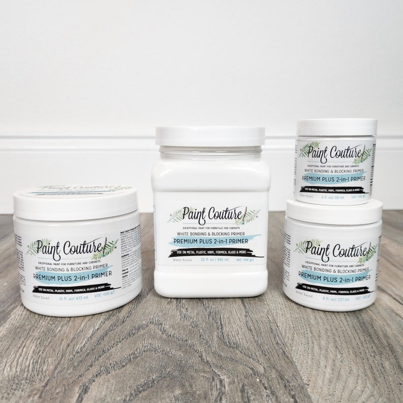 May include: Four white bottles of Paint Couture white bonding and blocking primer. The bottles are labelled "Premium Plus 2-in-1 Primer" and are available in 8 oz, 16 oz, and 32 oz sizes.