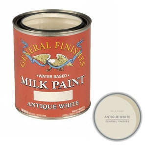 May include: A can of General Finishes Antique White Milk Paint. The can is red with a white label and features a gold eagle logo. The label says "Water Based" and "Milk Paint".