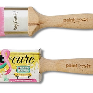 Pu&ograve; includere: Due pennelli per dipingere con manici in legno. Il pennello pi&ugrave; grande ha setole rosa e il pennello pi&ugrave; piccolo ha un nastro rosa con le parole "paint a cure" sul manico. Il pennello pi&ugrave; piccolo &egrave; confezionato in una scatola con le parole "The Painters "Pink Brush" 2" Flat Fine Synthetic" su di essa.