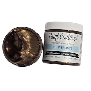 May include: A jar of metallic stencil paste in the color Aged Bronze. The paste is smooth and creamy with shimmer and is water-based. The jar is labeled "Paint Couture" and contains 4 fluid ounces (118 ml).