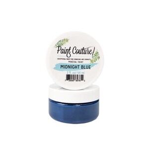 May include: A small jar of Midnight Blue mineral paint by Paint Couture. The jar is labeled with the brand name, paint type, and color. The jar contains 2 fluid ounces or 59 milliliters of paint.