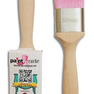 May include: A pink paint brush with a wooden handle and a silver ferrule. The brush is 50mm wide. The brush is packaged with a card that says "paint cure" and has a QR code. The card also says "PaintACureForGood.com" and "Read our story & join the fight". The card is sponsored by "CoCo ReStyled" and "Paint Couture".