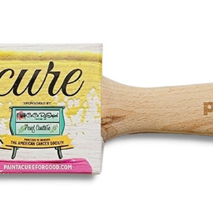 May include: A pink paint brush with a wooden handle. The brush is labelled "The Painters' "Pink Brush" 2" Flat Fine Synthetic" and has the words "paint a cure" on the handle.