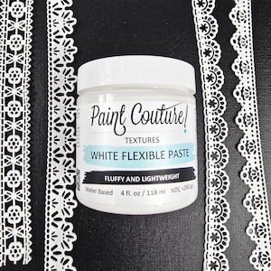 Puede incluir: Un tarro blanco de pasta flexible blanca "Paint Couture" con el texto "Fluffy and Lightweight". El tarro es de 118 ml. Ribete de encaje blanco a la izquierda y a la derecha del tarro.