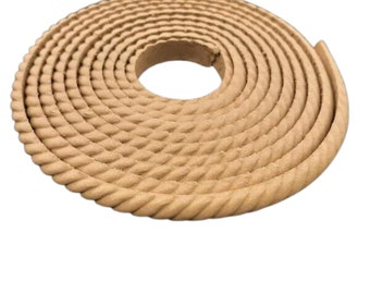May include: A roll of tan-coloured rope trim with a braided design. The rope is coiled in a circle.