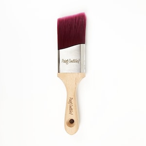 Pu&ograve; includere: Un pennello per pittura angolato con setole bordeaux e un manico in legno. Il manico &egrave; inciso con "Paint Couture".