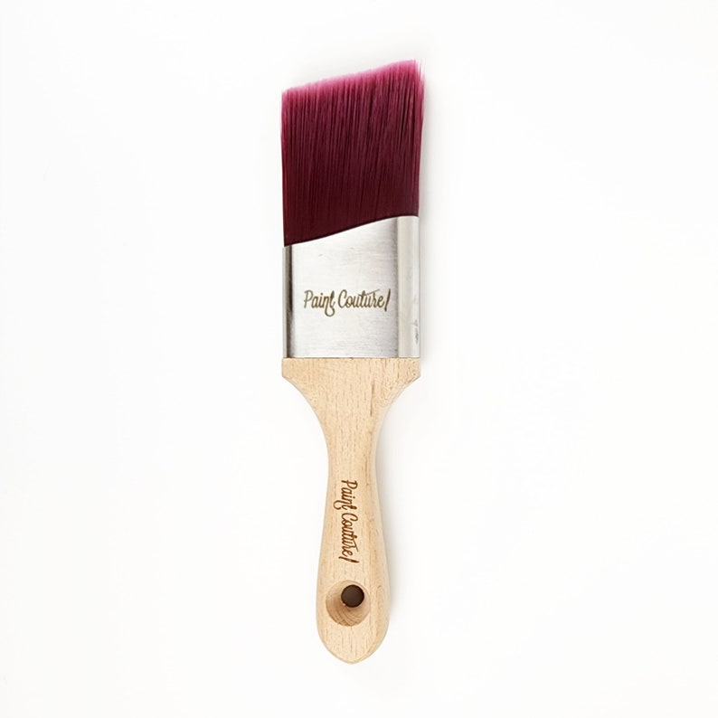 Pu&ograve; includere: Un pennello per pittura angolato con setole bordeaux e un manico in legno. Il manico &egrave; inciso con "Paint Couture".