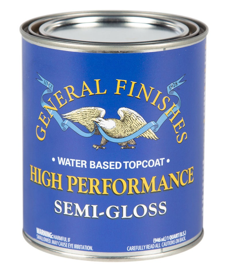 May include: A blue can of General Finishes High Performance Semi-Gloss water-based topcoat. The can features an eagle with a ribbon and the text "Since 1928". The can is labeled with a warning that the product is harmful if swallowed and may cause eye irritation.