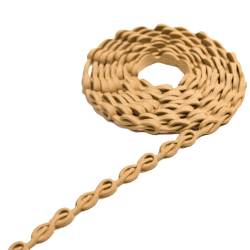 May include: A close-up of a beige braided trim, coiled into a circle. The trim is made of a soft, flexible material and has a woven pattern.
