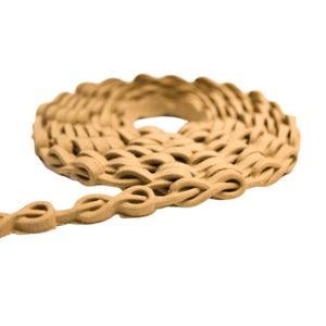 May include: A close-up of a brown, braided rope coiled into a circle. The rope is made of a soft, textured material and has a slightly rough surface.