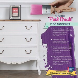 May include: A pink paint brush with a wooden handle and the text "The Painters' Pink Brush 2" Flat Fine Synthetic" and "Paint Care". The brush is shown against a white dresser with three drawers and a purple paint splatter in the background. The text "Proceeds to Benefit: The American Cancer Society" is also visible.