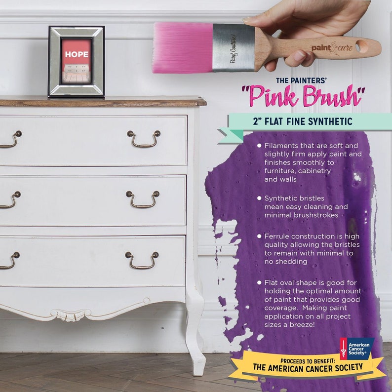 May include: A pink paint brush with a wooden handle and the text "The Painters' Pink Brush 2" Flat Fine Synthetic" and "Paint Care". The brush is shown against a white dresser with three drawers and a purple paint splatter in the background. The text "Proceeds to Benefit: The American Cancer Society" is also visible.