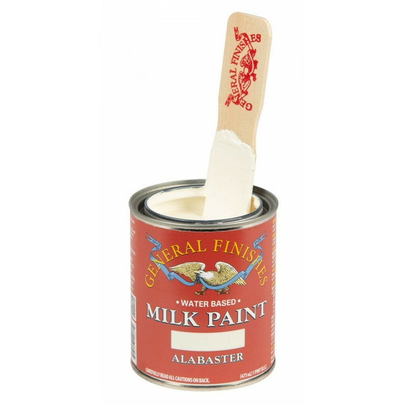 May include: A can of General Finishes Milk Paint in the color Alabaster. The paint is water-based and is shown with a wooden stir stick.